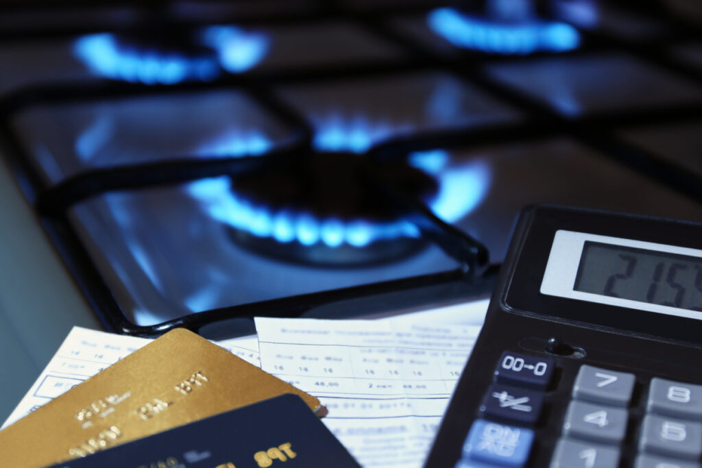 bank cards and a calculator on the background of a gas stove - em360