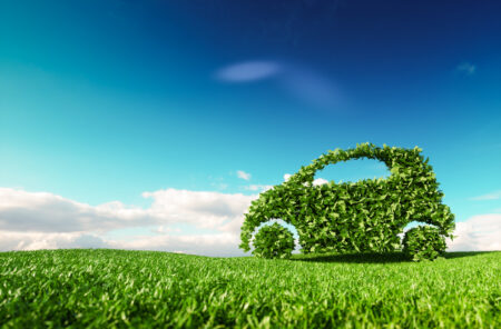 Eco friendly car development, clear ecology driving, no pollution and emmission transportation concept. 3d rendering of green car icon on fresh spring meadow with blue sky in background em360